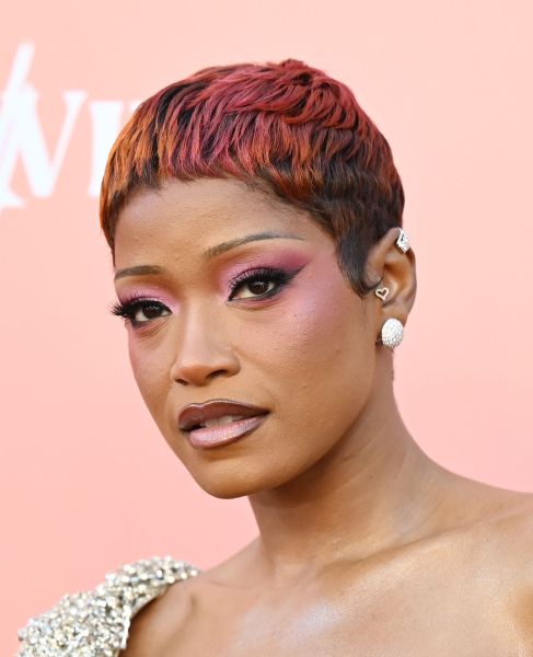 Keke Palmer appears at an event in a red and dark pink pixie cut and pink eyeshadow.